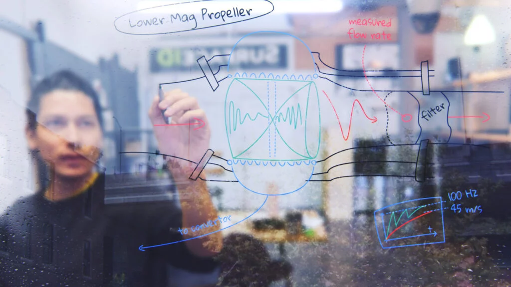 mechanical engineer sketching concepts on clear glass