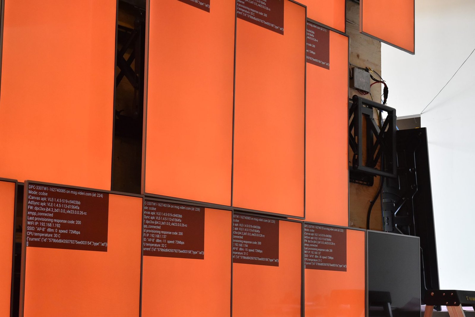 LCD Design and Commercial Integration at Scale: The ArcLight Cinemas StoryWall 9 LCD video wall screens lit solid orange for testing, with gaps where screens are out